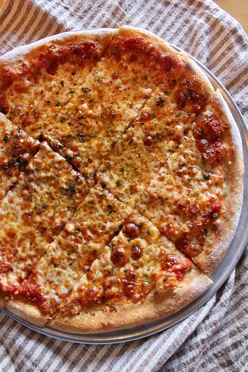 Top-down shot of a cheesy pizza on a rustic cloth, inviting and delectable.